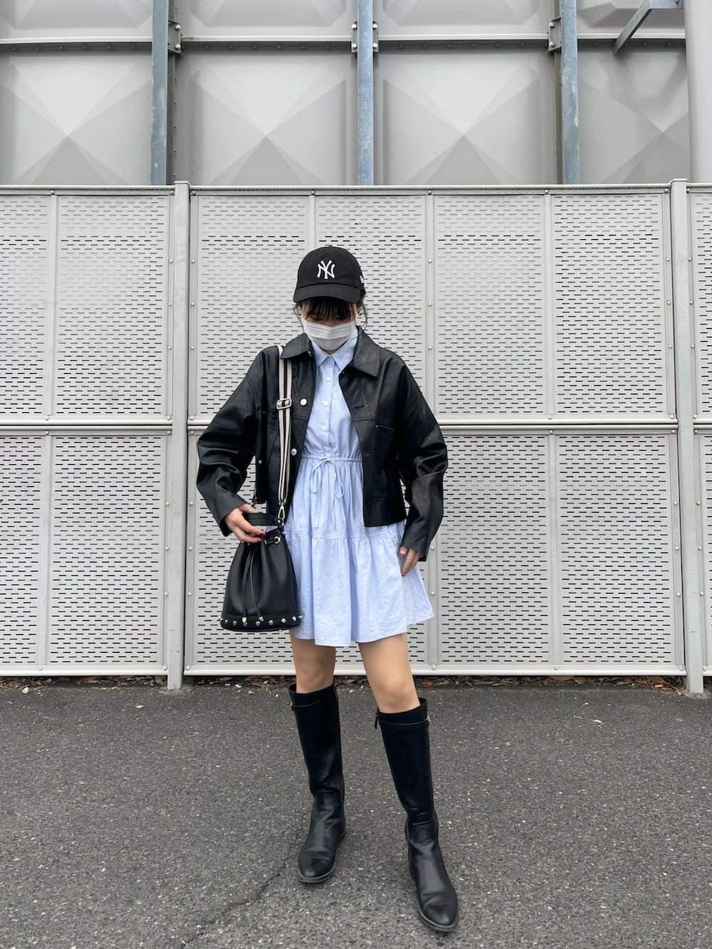 ブラック系のブーツ、ブルー系のワンピース、ブラック系のジャケット/アウターを着用したレディースの春コーディネートの3枚目の写真