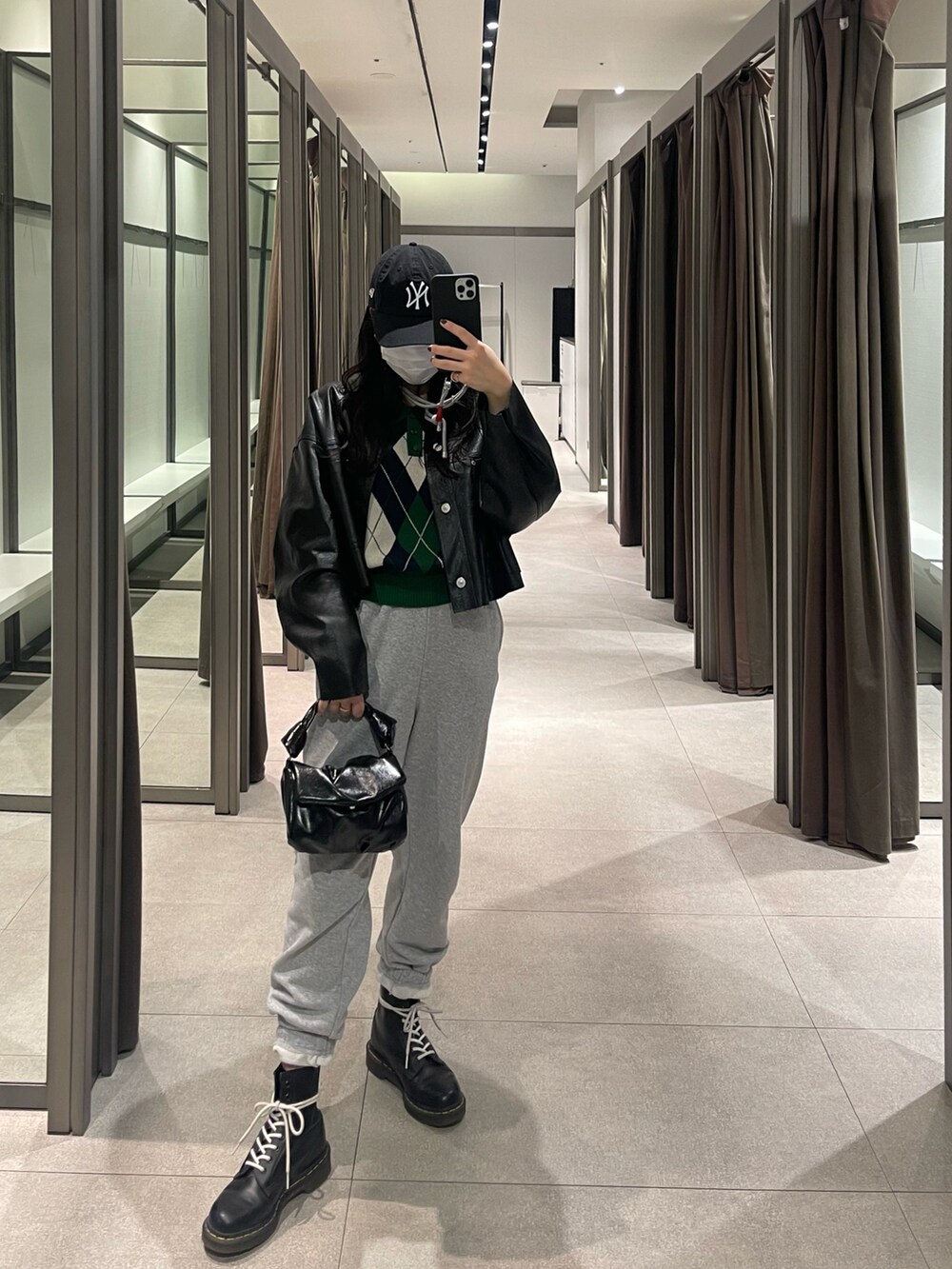 グリーン系のニット/セーター、ブラック系のバッグ、ブラック系のブーツを着用したレディースの冬コーディネートの2枚目の写真