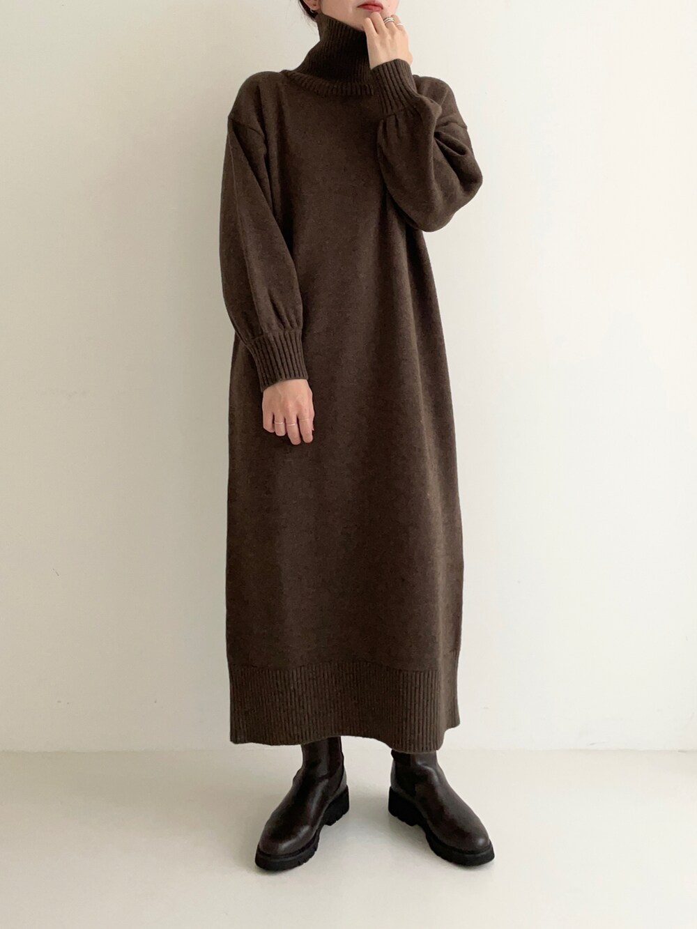 ブラウン系のワンピース、オレンジ系のニット/セーター、ブラウン系のブーツを着用したレディースの秋コーディネートの3枚目の写真