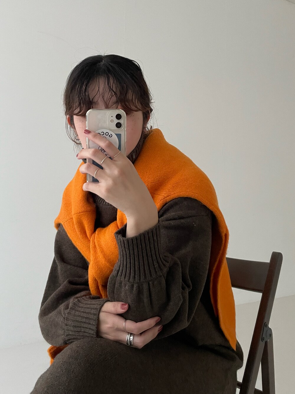 ブラウン系のワンピース、オレンジ系のニット/セーター、ブラウン系のブーツを着用したレディースの秋コーディネートの2枚目の写真