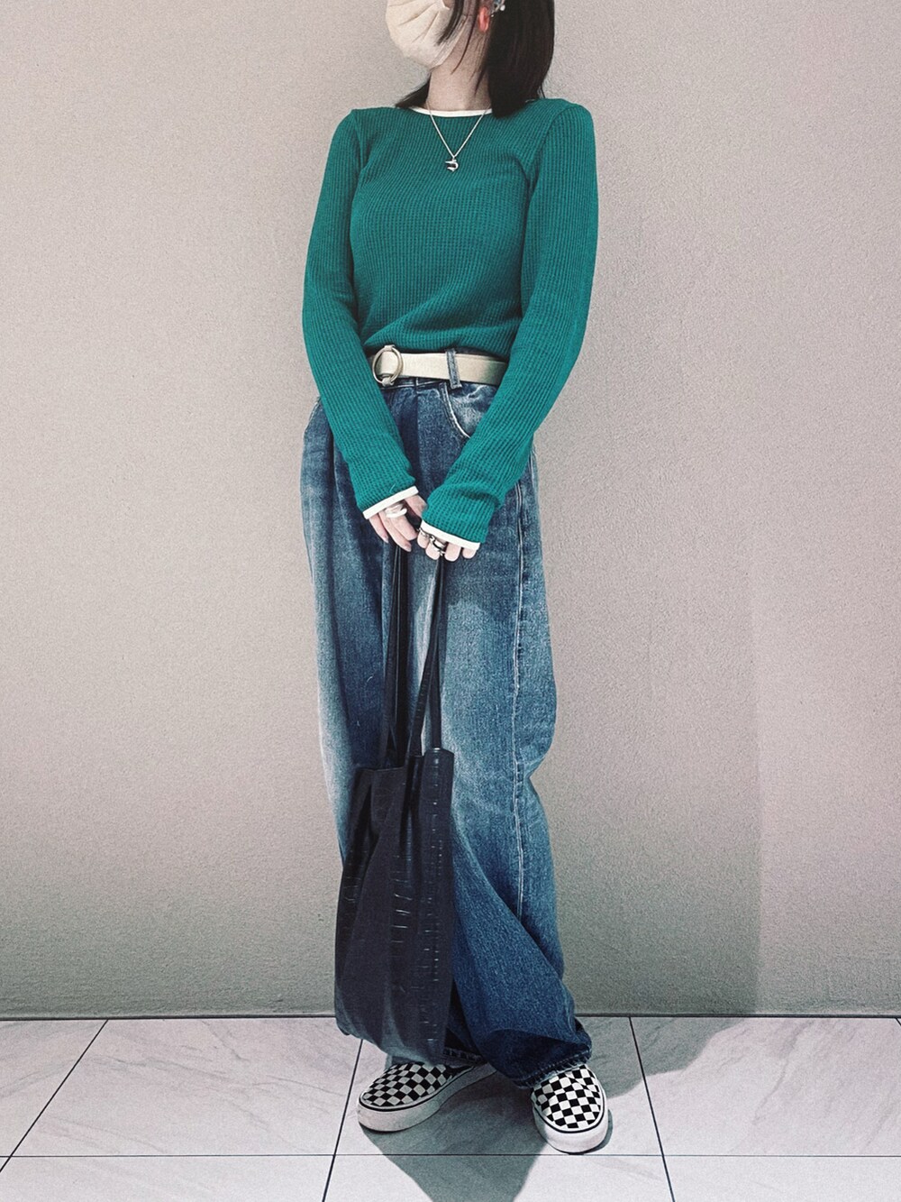 グリーン系のTシャツ/カットソー、ブルー系のデニムパンツ、ブラック系のトートバッグを着用したレディースの秋コーディネートの2枚目の写真