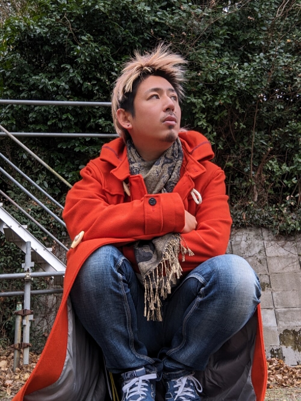 オレンジ系のダッフルコート、ブルー系のスニーカーを着用したメンズの冬コーディネートの2枚目の写真