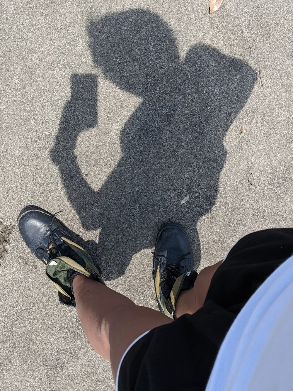 ホワイト系のタンクトップ、ブラック系のその他パンツ、グリーン系のブーツを着用したメンズの春コーディネートの2枚目の写真