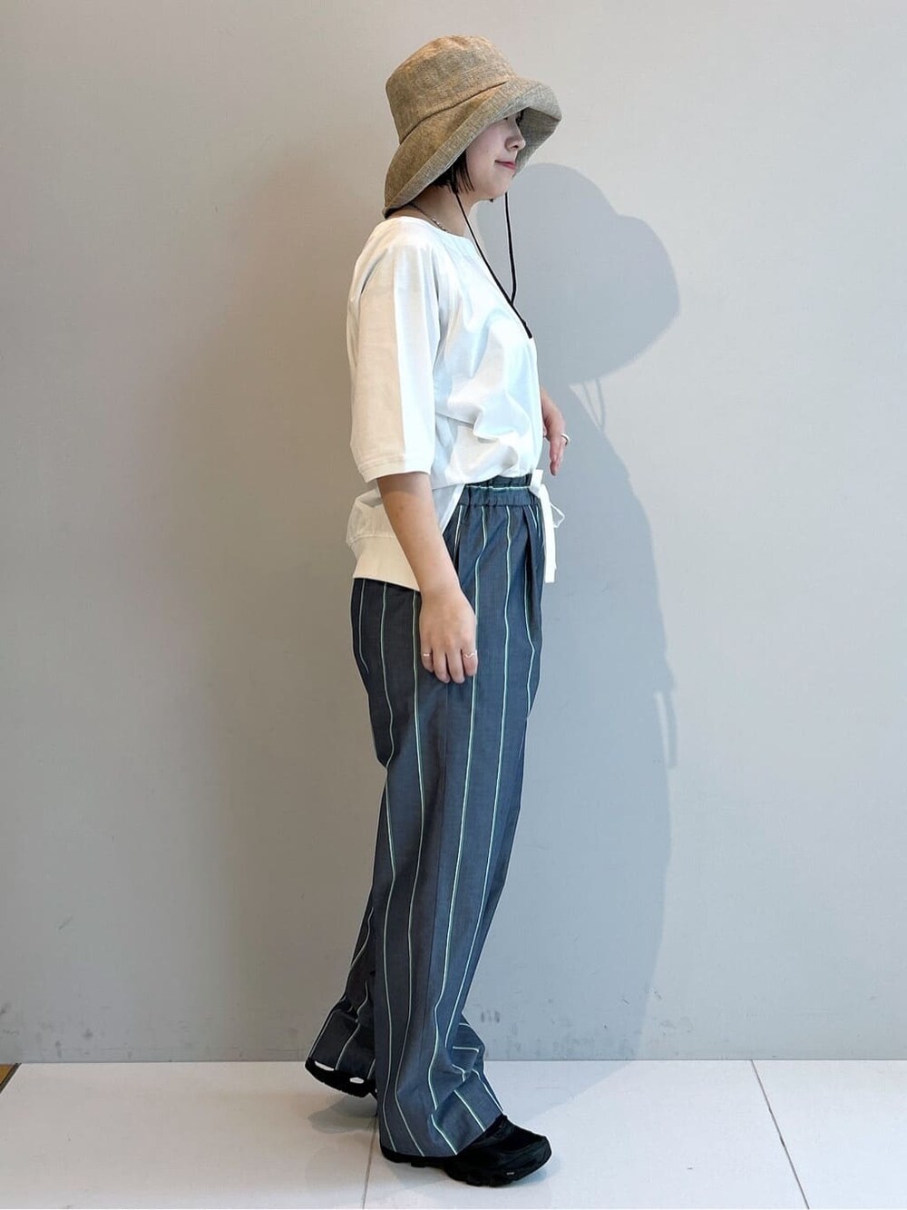 ホワイト系のTシャツ/カットソー、ブルー系のその他パンツ、ベージュ系のハットを着用したレディースの春コーディネートの4枚目の写真