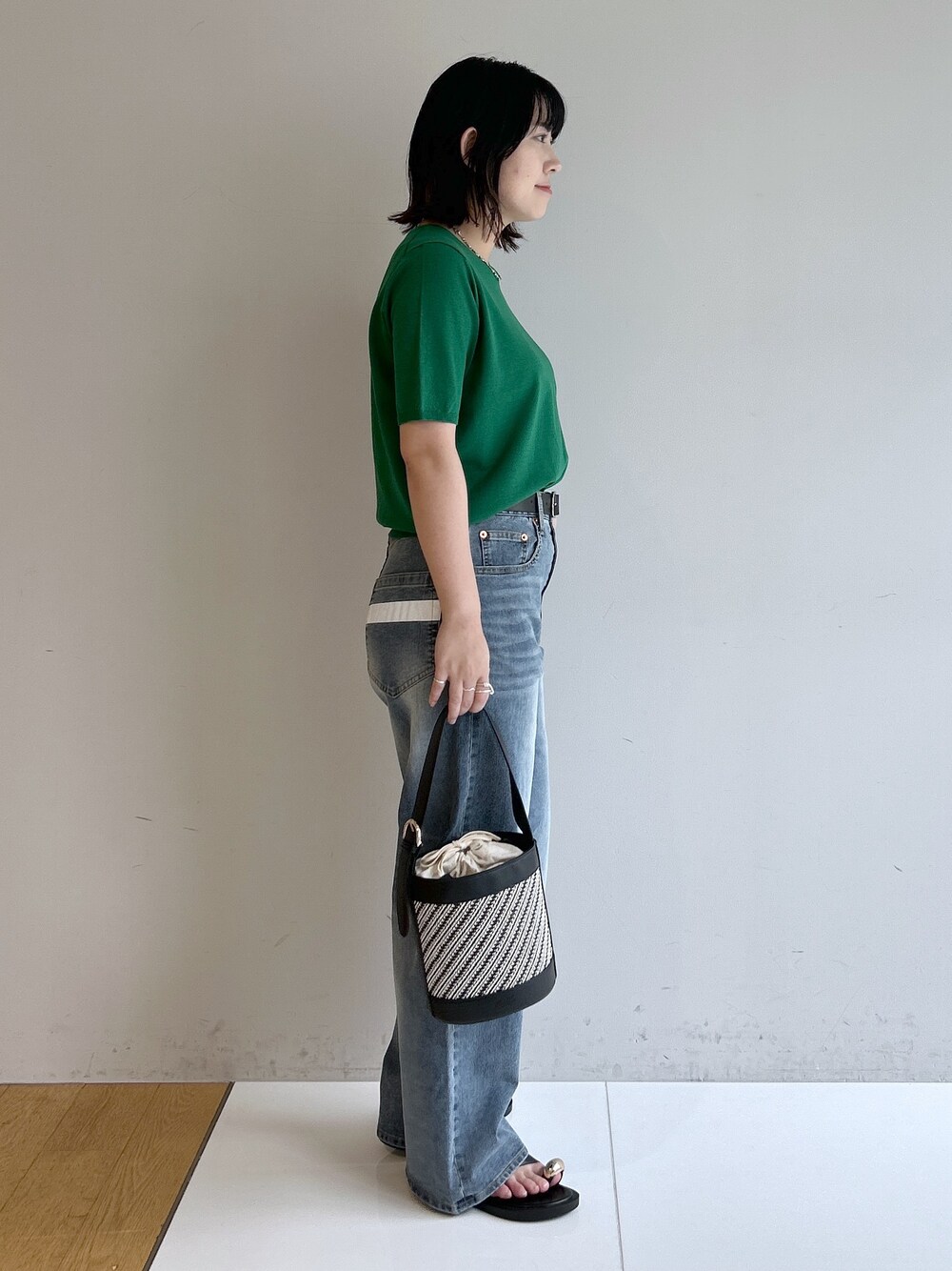 グリーン系のニット/セーター、ブルー系のその他パンツ、ブラック系のショルダーバッグを着用したレディースの夏コーディネートの4枚目の写真