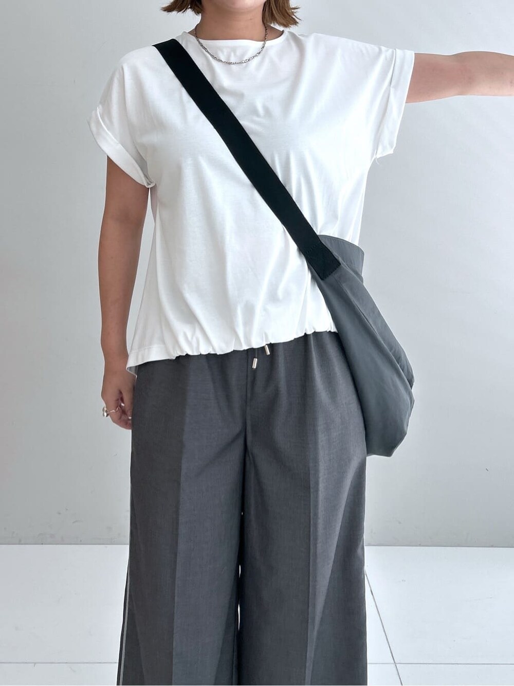 ホワイト系のTシャツ/カットソー、グレー系のその他パンツ、グレー系のショルダーバッグを着用したレディースの夏コーディネートの6枚目の写真