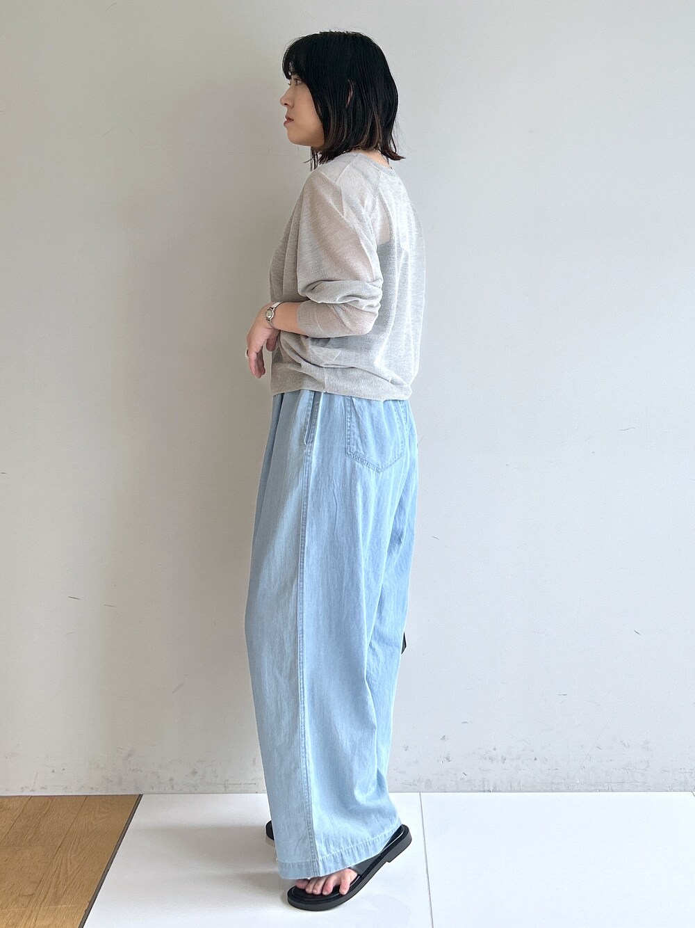 ブルー系のデニムパンツ、ブラック系のショルダーバッグ、ブラック系のサンダルを着用したレディースの夏コーディネートの2枚目の写真