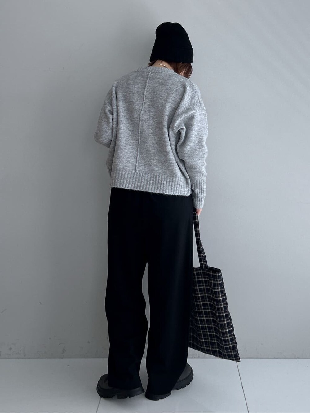 グレー系のニット/セーター、ブラック系のその他パンツ、グレー系のブーツを着用したレディースの秋コーディネートの3枚目の写真