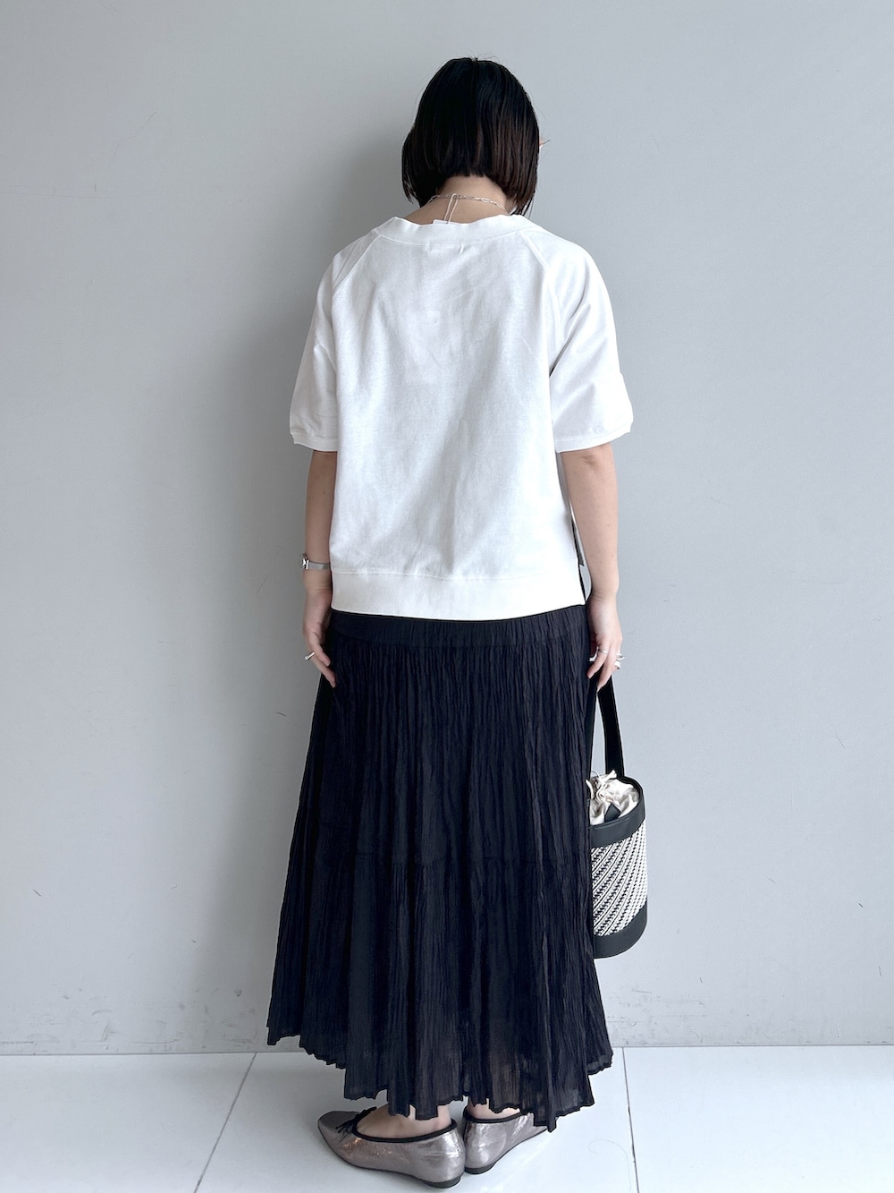 グレー系のカーディガン/ボレロ、ホワイト系のTシャツ/カットソー、ブラック系のスカートを着用したレディースの春コーディネートの3枚目の写真