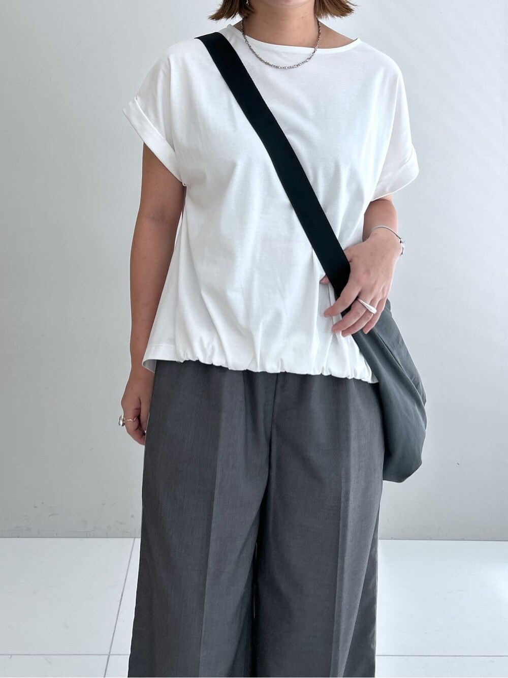 ホワイト系のTシャツ/カットソー、グレー系のその他パンツ、グレー系のショルダーバッグを着用したレディースの夏コーディネートの7枚目の写真