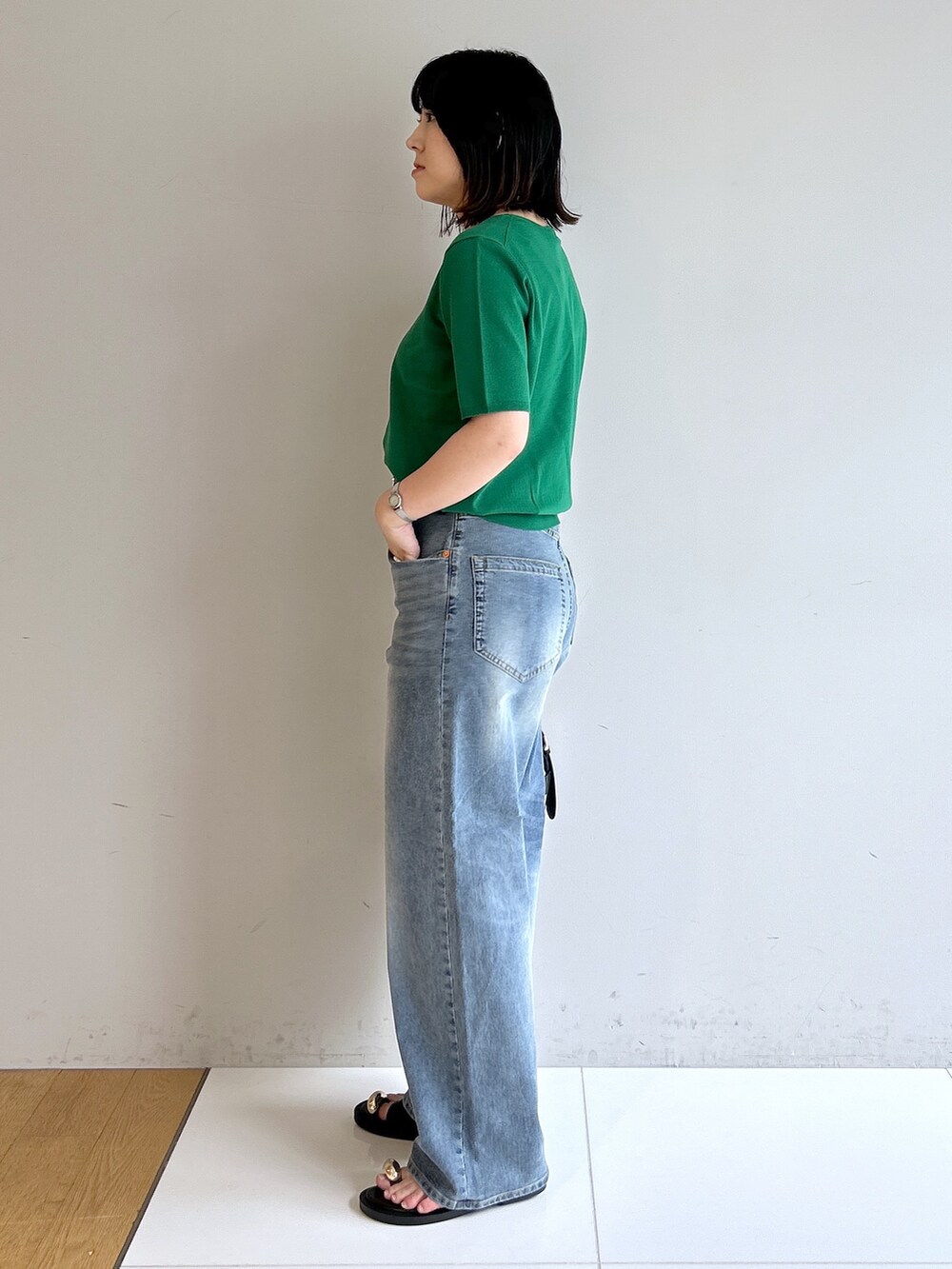 グリーン系のニット/セーター、ブルー系のその他パンツ、ブラック系のショルダーバッグを着用したレディースの夏コーディネートの2枚目の写真