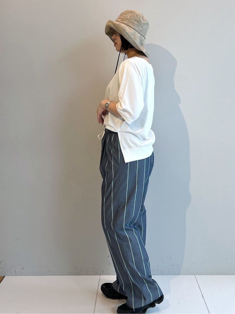 ホワイト系のTシャツ/カットソー、ブルー系のその他パンツ、ベージュ系のハットを着用したレディースの春コーディネートの2枚目の写真