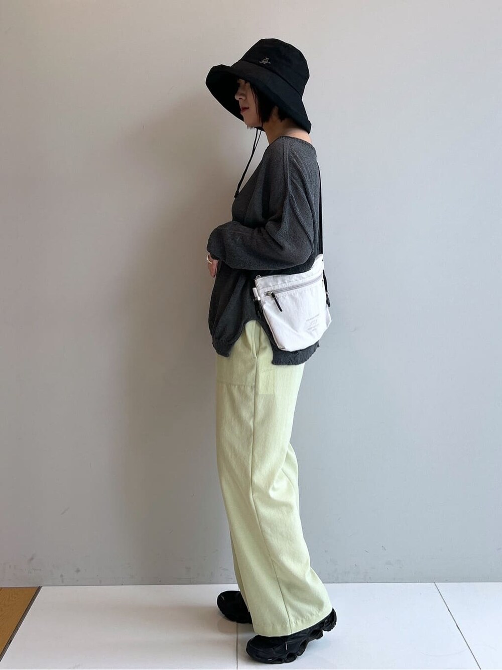 イエロー系のその他パンツ、ブラック系のハットを着用したレディースの春コーディネートの2枚目の写真