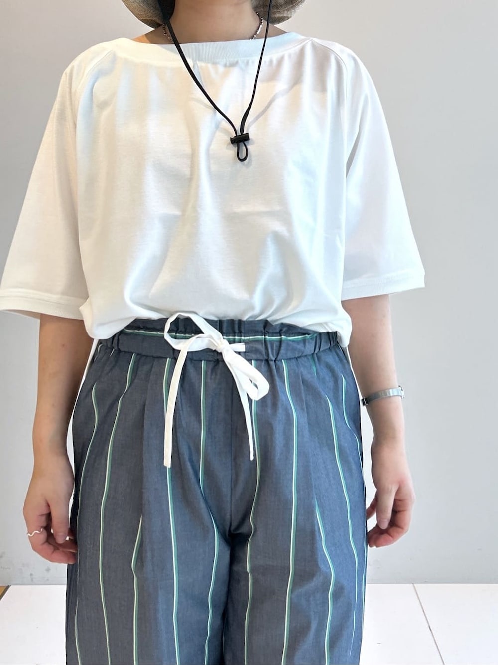 ホワイト系のTシャツ/カットソー、ブルー系のその他パンツ、ベージュ系のハットを着用したレディースの春コーディネートの6枚目の写真