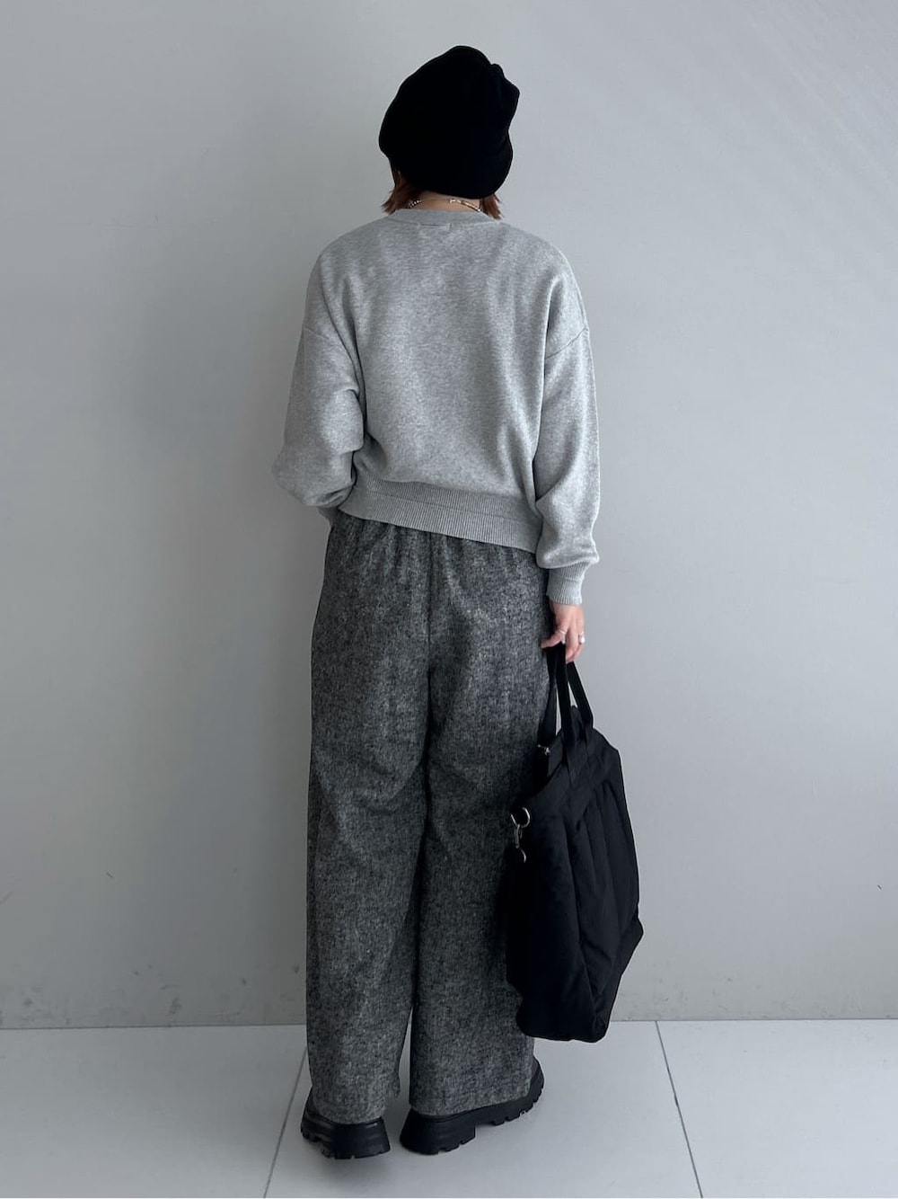 グレー系のニット/セーター、ブラック系のその他パンツ、ブラック系のダウンジャケット/コートを着用したレディースの秋コーディネートの3枚目の写真