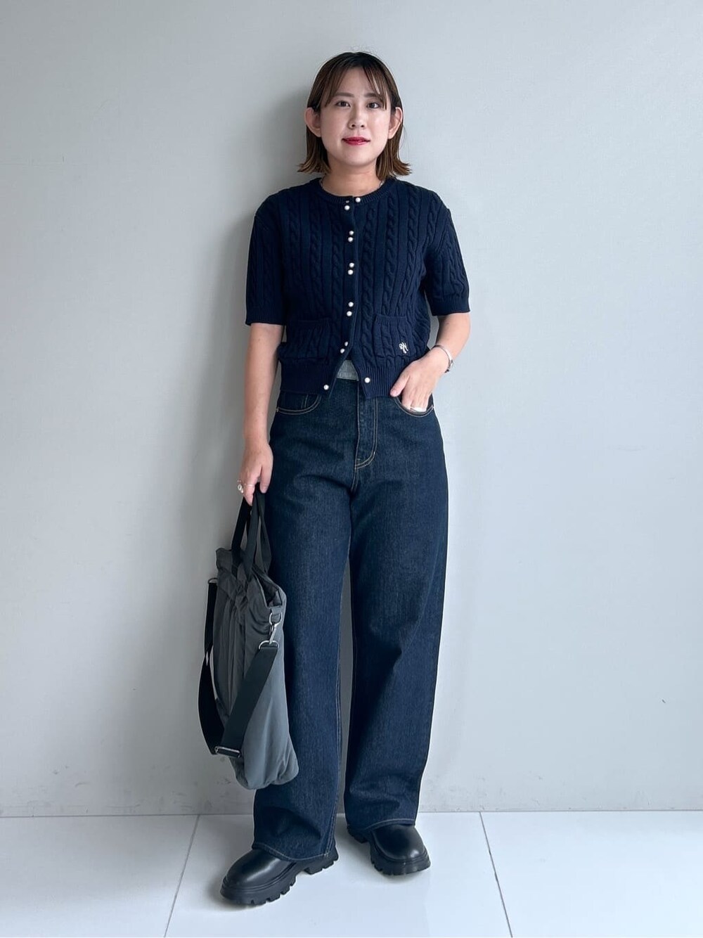 ブルー系のカーディガン/ボレロ、ブルー系のデニムパンツ、ブラック系のブーツを着用したレディースの秋コーディネートの5枚目の写真