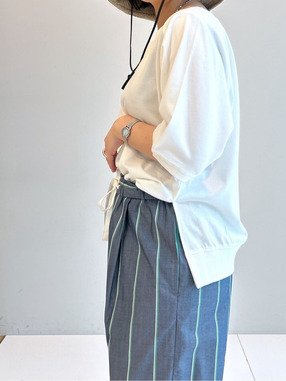 ホワイト系のTシャツ/カットソー、ブルー系のその他パンツ、ベージュ系のハットを着用したレディースの春コーディネートの7枚目の写真
