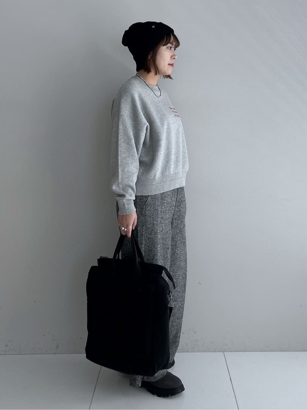 グレー系のニット/セーター、ブラック系のその他パンツ、ブラック系のダウンジャケット/コートを着用したレディースの秋コーディネートの4枚目の写真