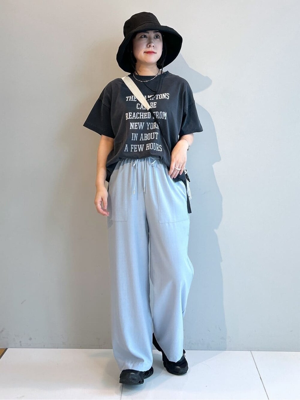 グレー系のTシャツ/カットソー、ブルー系のその他パンツ、ホワイト系のショルダーバッグを着用したレディースの春コーディネートの5枚目の写真