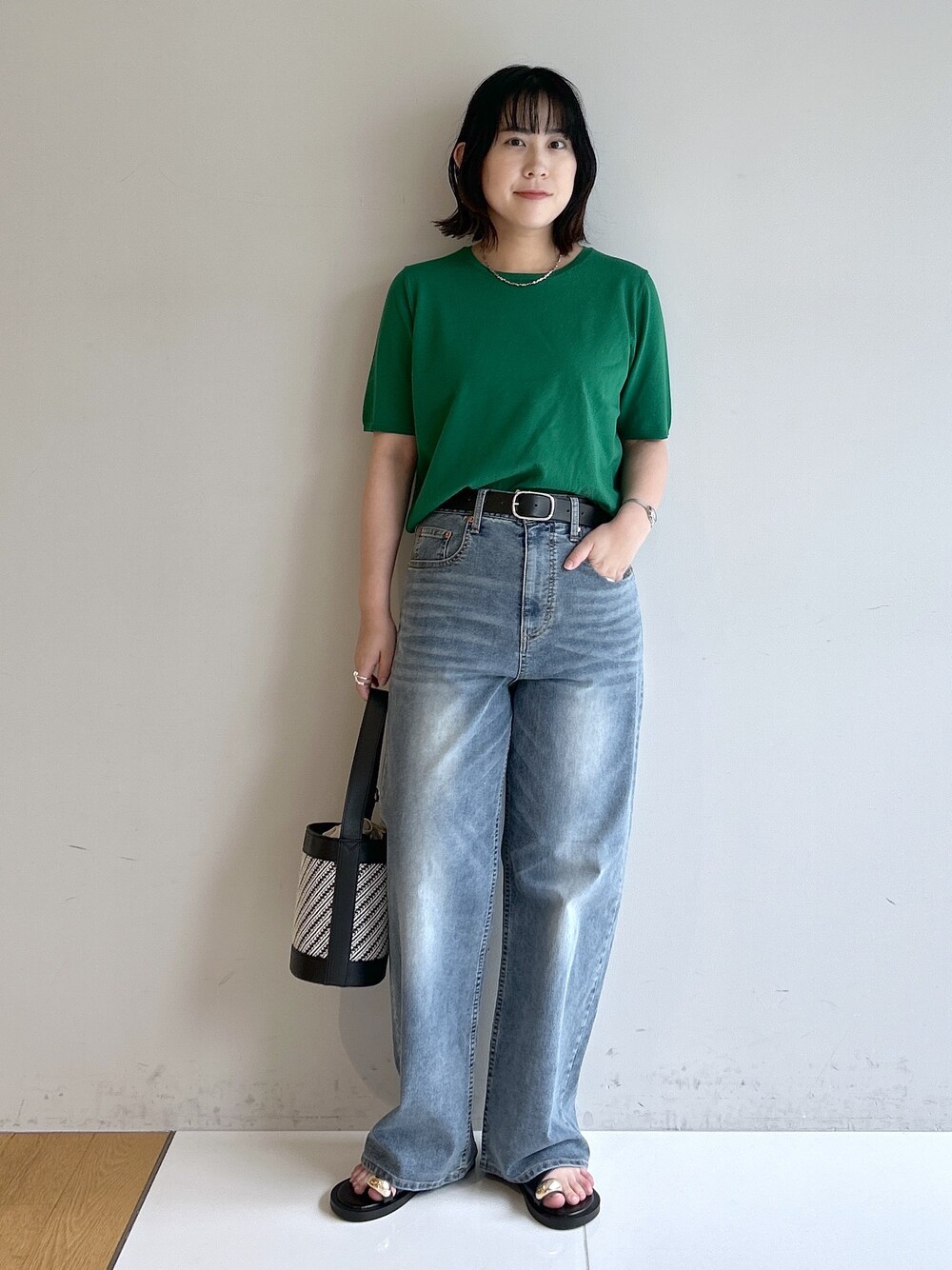 グリーン系のニット/セーター、ブルー系のその他パンツ、ブラック系のショルダーバッグを着用したレディースの夏コーディネートの5枚目の写真
