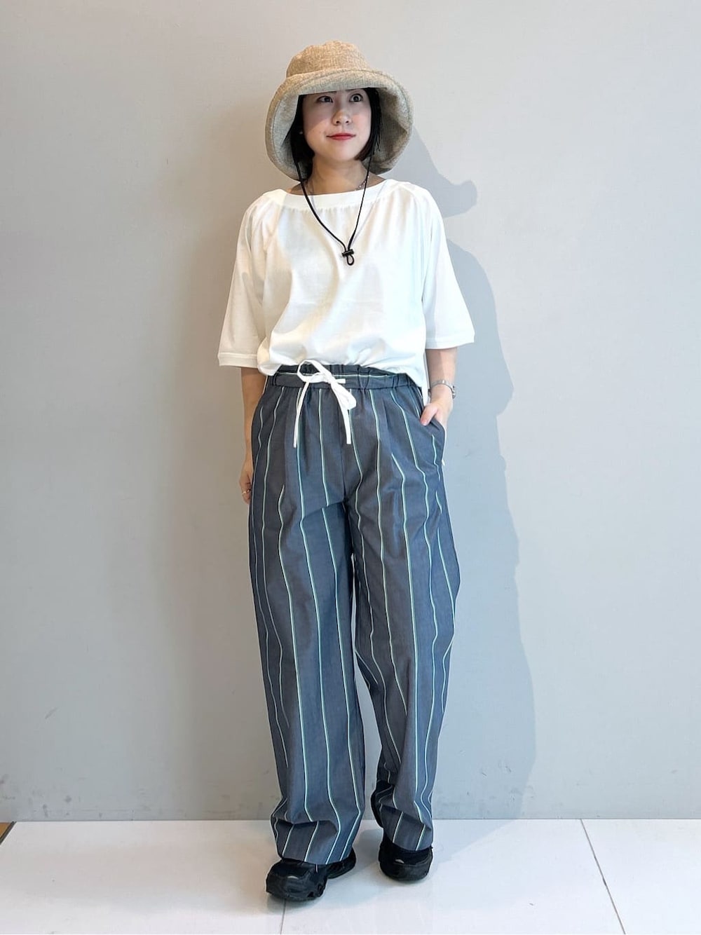 ホワイト系のTシャツ/カットソー、ブルー系のその他パンツ、ベージュ系のハットを着用したレディースの春コーディネートの5枚目の写真