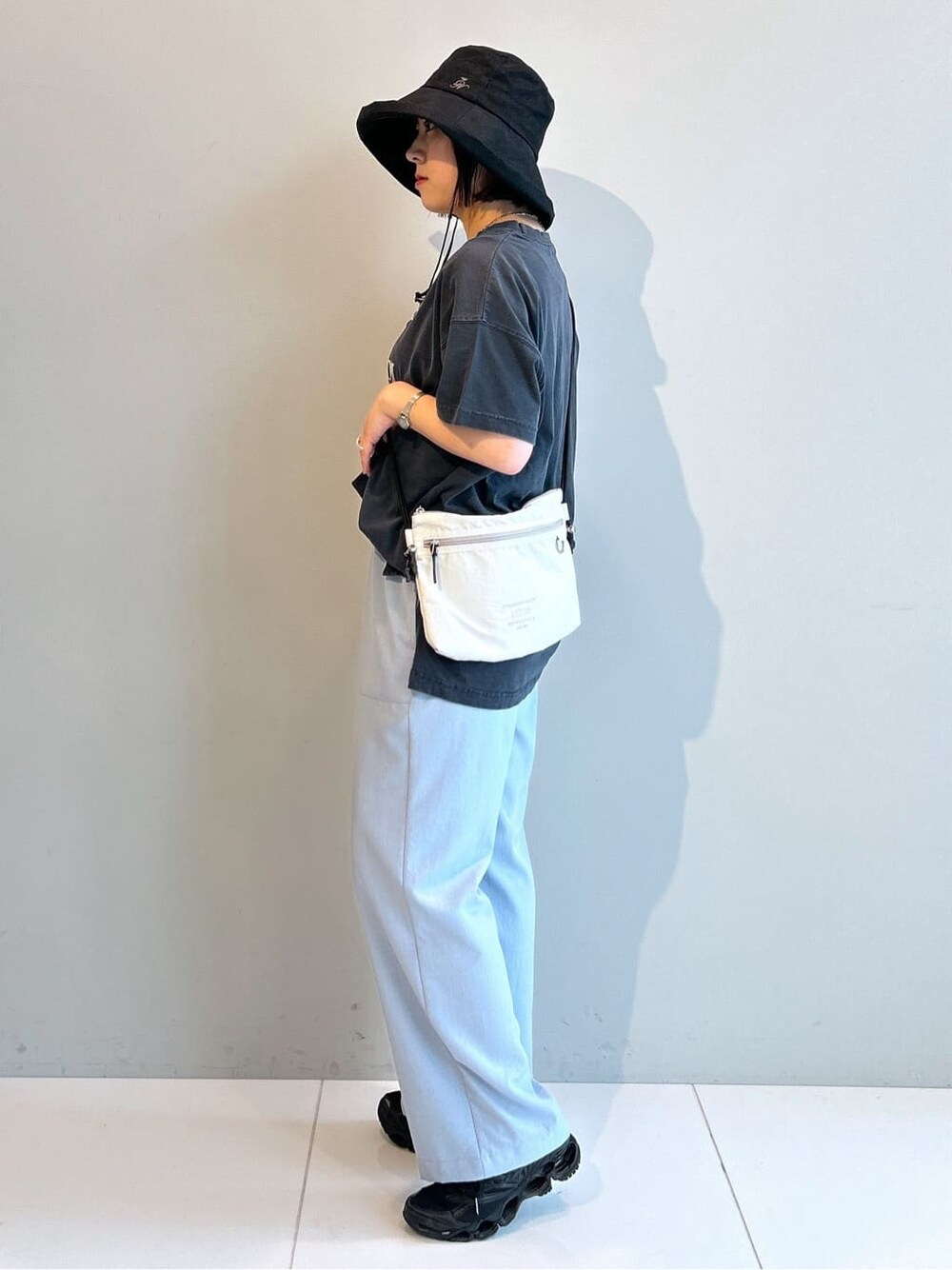グレー系のTシャツ/カットソー、ブルー系のその他パンツ、ホワイト系のショルダーバッグを着用したレディースの春コーディネートの2枚目の写真