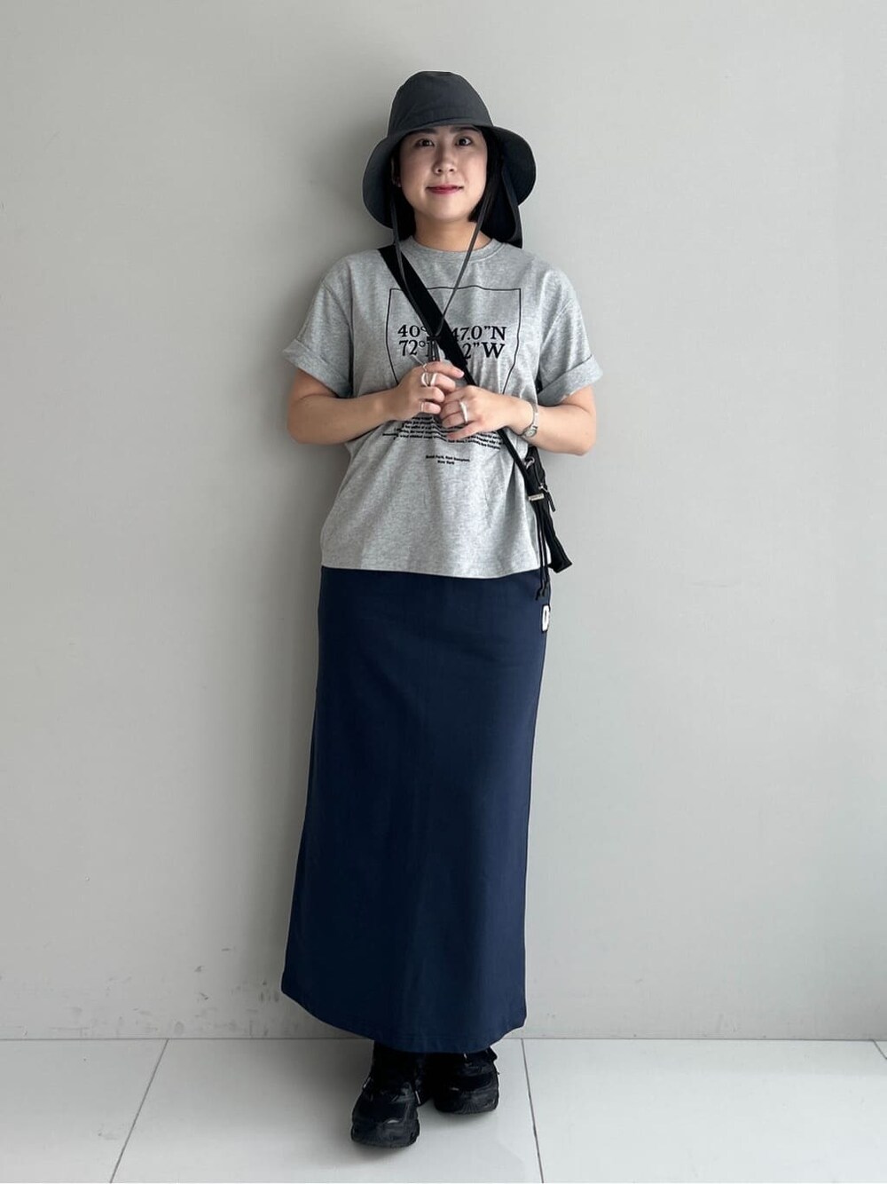 グレー系のTシャツ/カットソー、ブルー系のスカート、ブラック系のショルダーバッグを着用したレディースの夏コーディネートの9枚目の写真