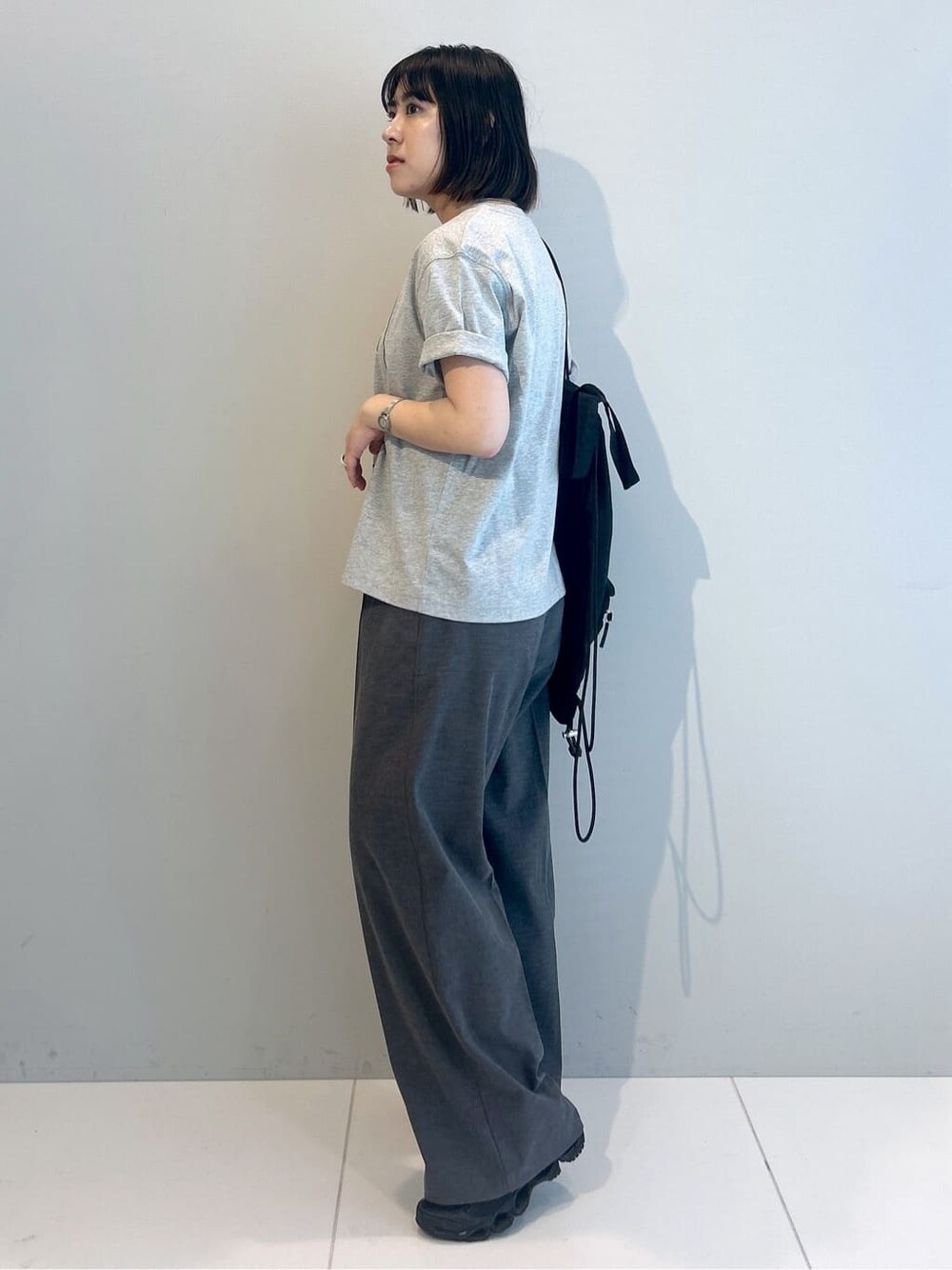 グレー系のTシャツ/カットソー、グレー系のその他パンツ、ブラック系のバックパック/リュックを着用したレディースの春コーディネートの6枚目の写真