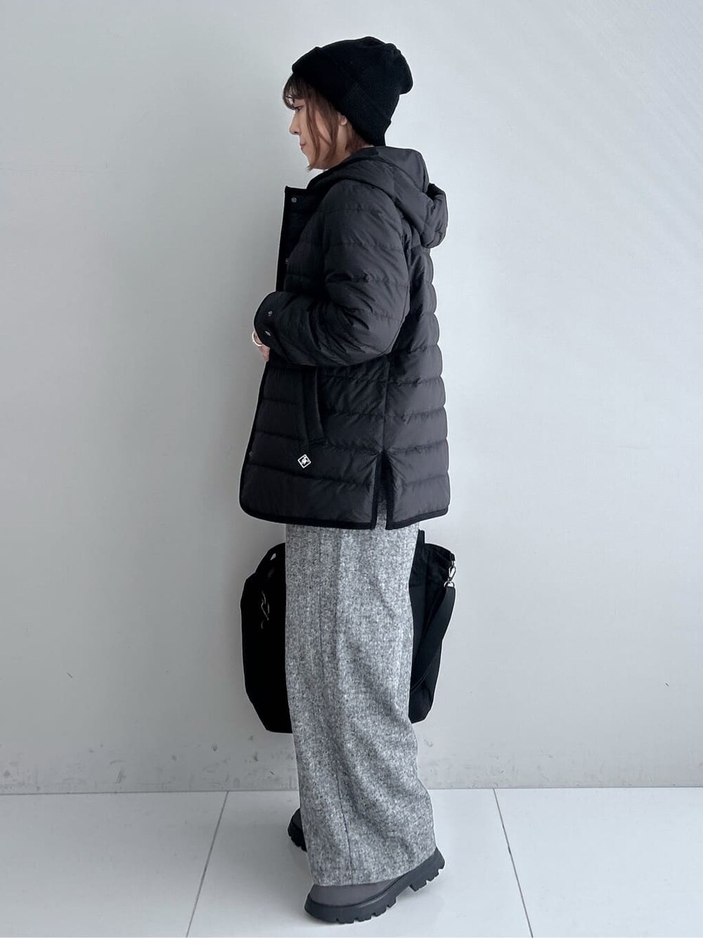 グレー系のニット/セーター、ブラック系のその他パンツ、ブラック系のダウンジャケット/コートを着用したレディースの秋コーディネートの8枚目の写真