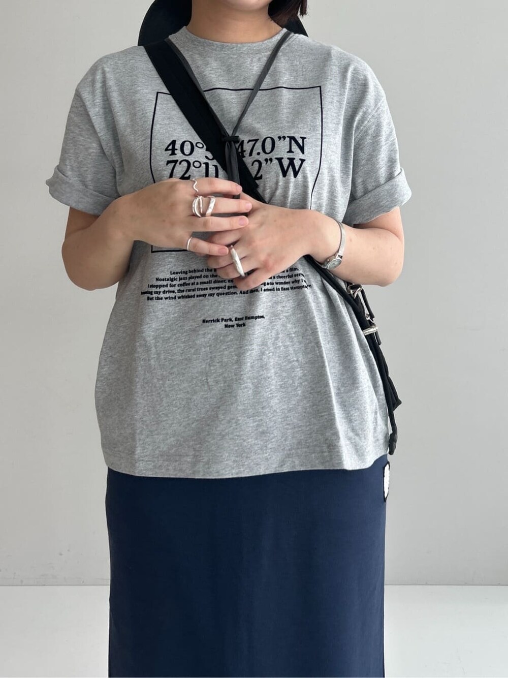 グレー系のTシャツ/カットソー、ブルー系のスカート、ブラック系のショルダーバッグを着用したレディースの夏コーディネートの6枚目の写真