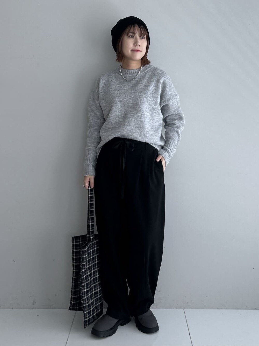 グレー系のニット/セーター、ブラック系のその他パンツ、グレー系のブーツを着用したレディースの秋コーディネートの8枚目の写真