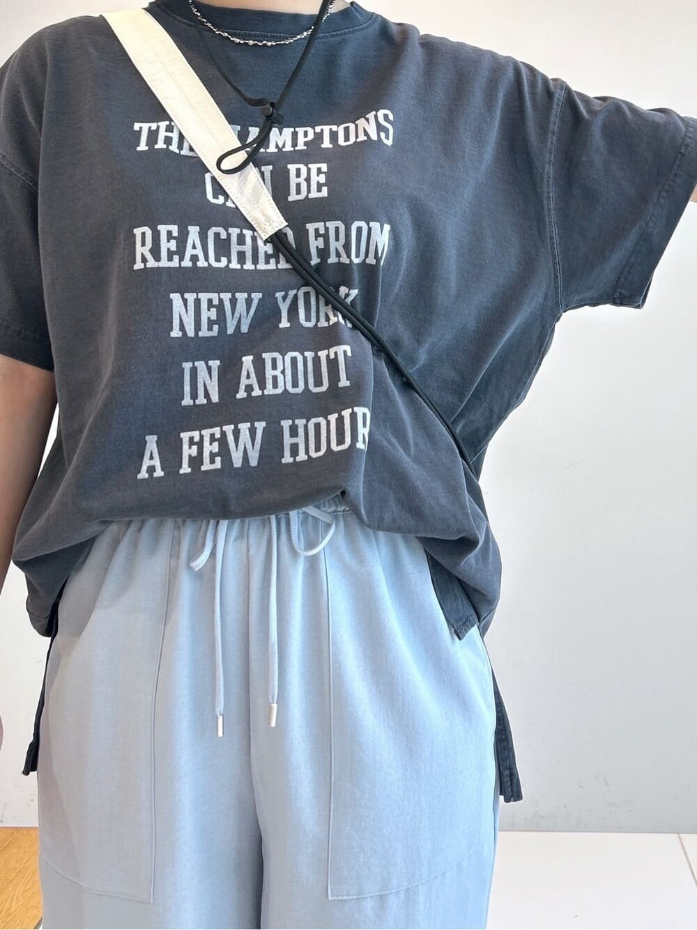 グレー系のTシャツ/カットソー、ブルー系のその他パンツ、ホワイト系のショルダーバッグを着用したレディースの春コーディネートの6枚目の写真
