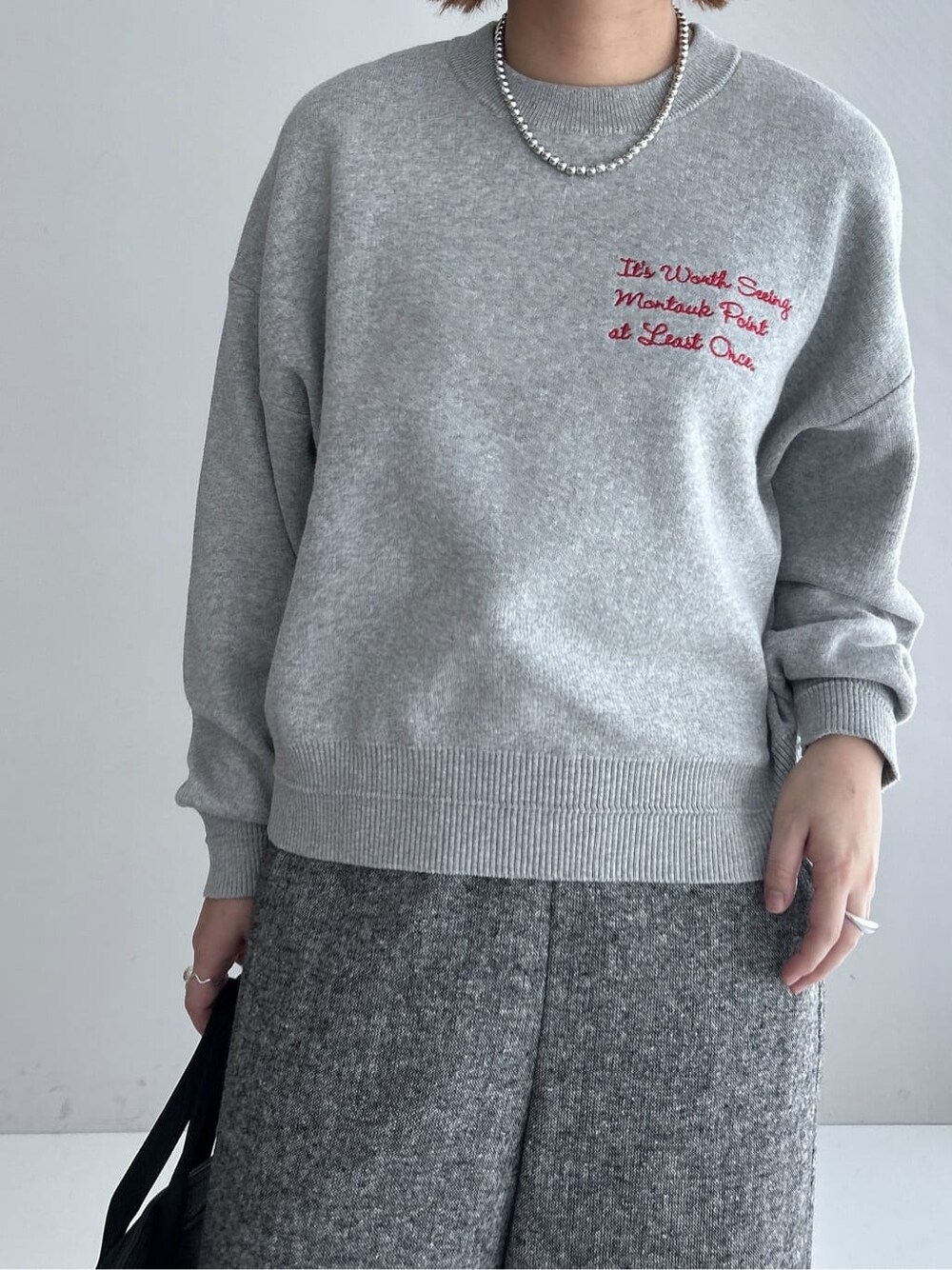 グレー系のニット/セーター、ブラック系のその他パンツ、ブラック系のダウンジャケット/コートを着用したレディースの秋コーディネートの5枚目の写真
