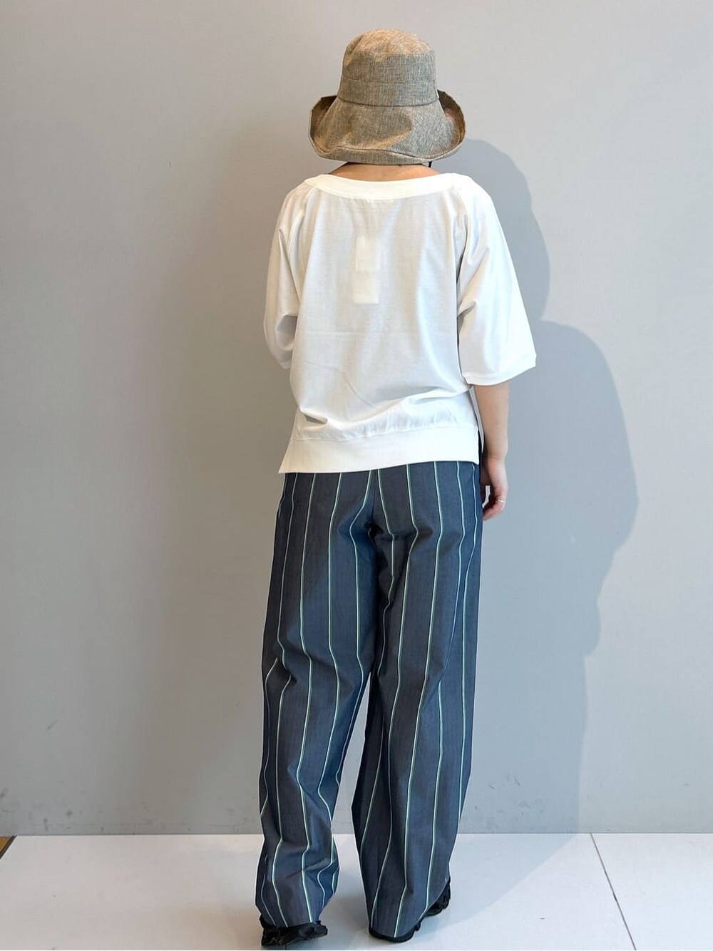 ホワイト系のTシャツ/カットソー、ブルー系のその他パンツ、ベージュ系のハットを着用したレディースの春コーディネートの3枚目の写真