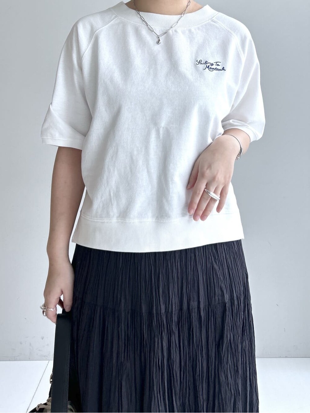グレー系のカーディガン/ボレロ、ホワイト系のTシャツ/カットソー、ブラック系のスカートを着用したレディースの春コーディネートの5枚目の写真