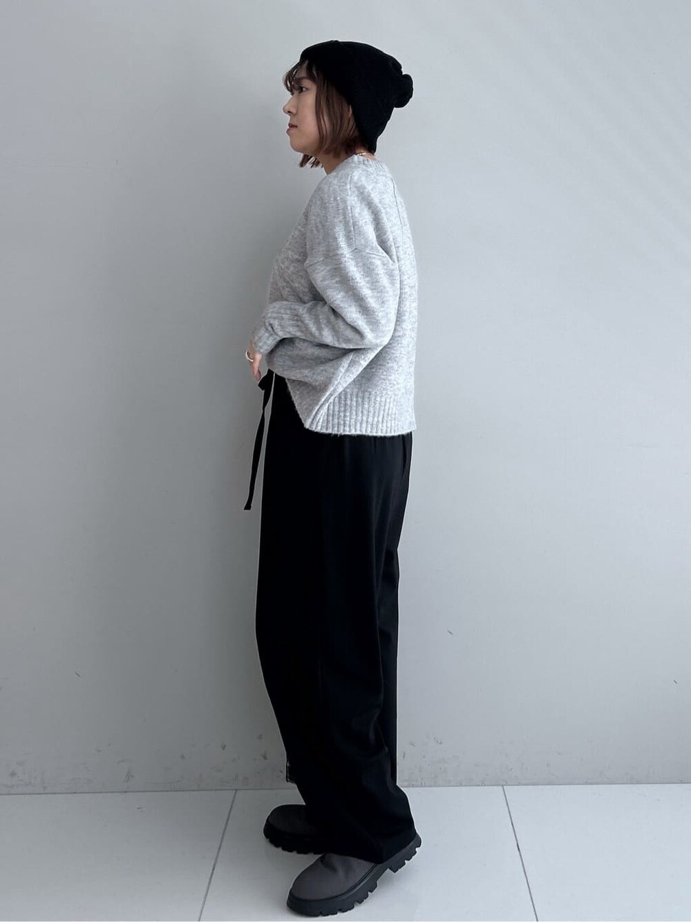 グレー系のニット/セーター、ブラック系のその他パンツ、グレー系のブーツを着用したレディースの秋コーディネートの2枚目の写真