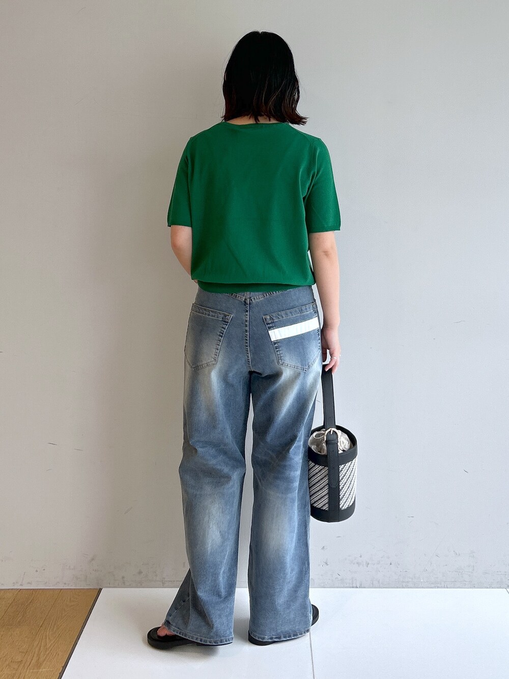 グリーン系のニット/セーター、ブルー系のその他パンツ、ブラック系のショルダーバッグを着用したレディースの夏コーディネートの3枚目の写真