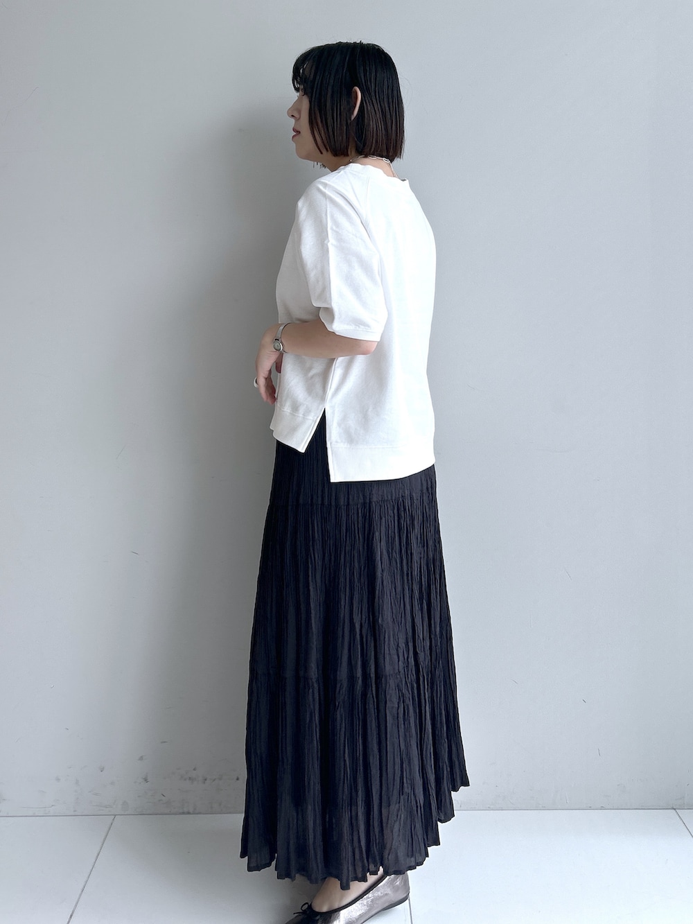グレー系のカーディガン/ボレロ、ホワイト系のTシャツ/カットソー、ブラック系のスカートを着用したレディースの春コーディネートの2枚目の写真