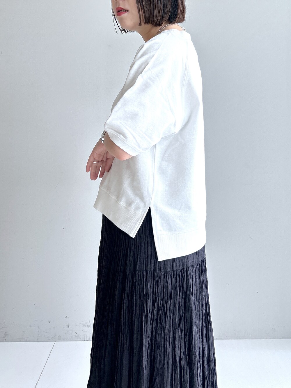 グレー系のカーディガン/ボレロ、ホワイト系のTシャツ/カットソー、ブラック系のスカートを着用したレディースの春コーディネートの6枚目の写真
