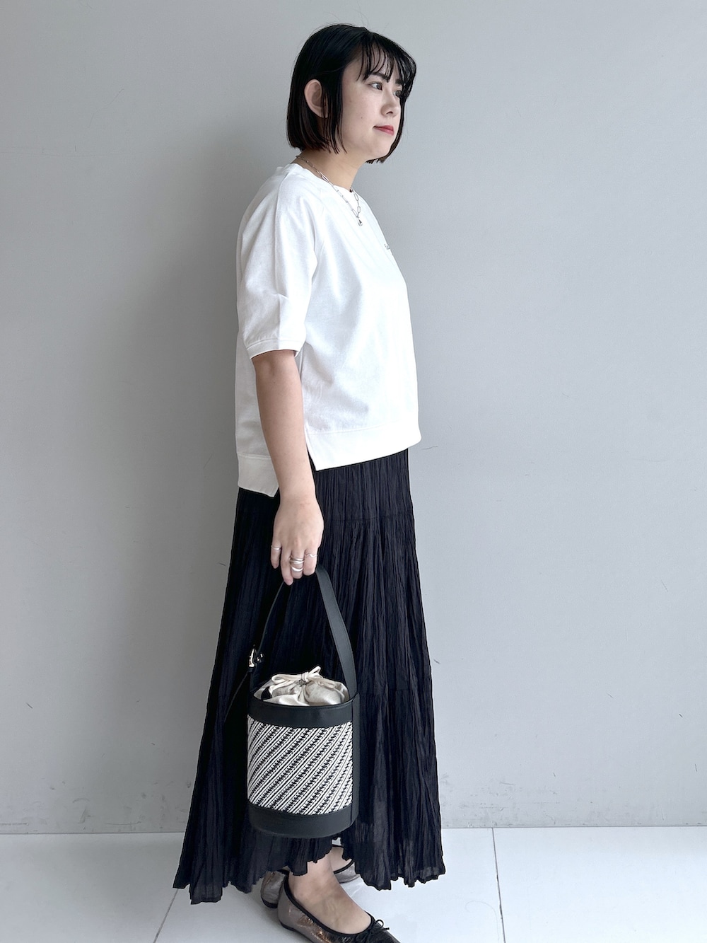 グレー系のカーディガン/ボレロ、ホワイト系のTシャツ/カットソー、ブラック系のスカートを着用したレディースの春コーディネートの4枚目の写真