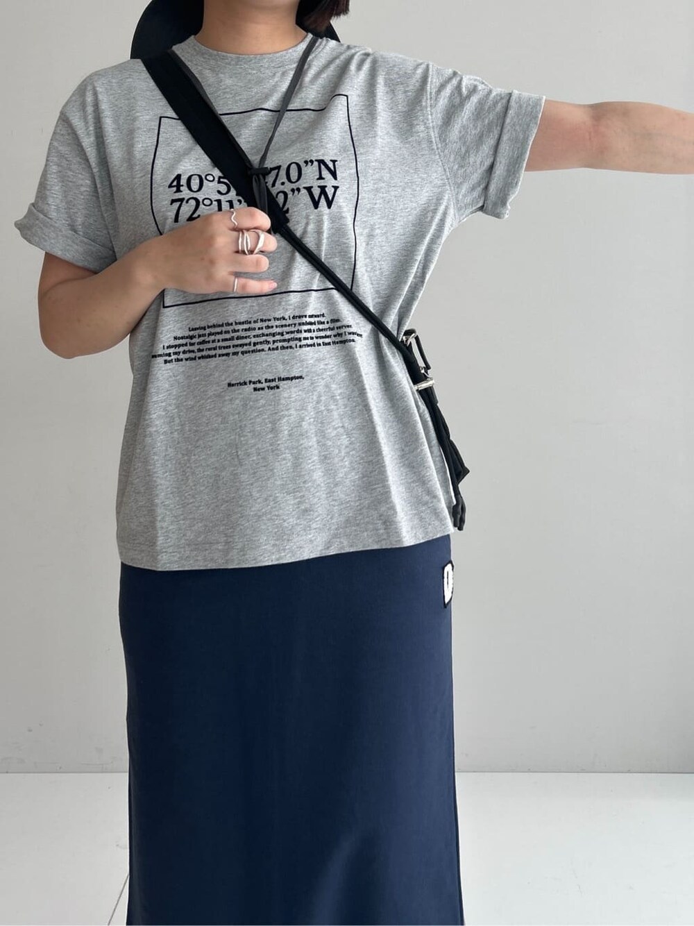 グレー系のTシャツ/カットソー、ブルー系のスカート、ブラック系のショルダーバッグを着用したレディースの夏コーディネートの8枚目の写真