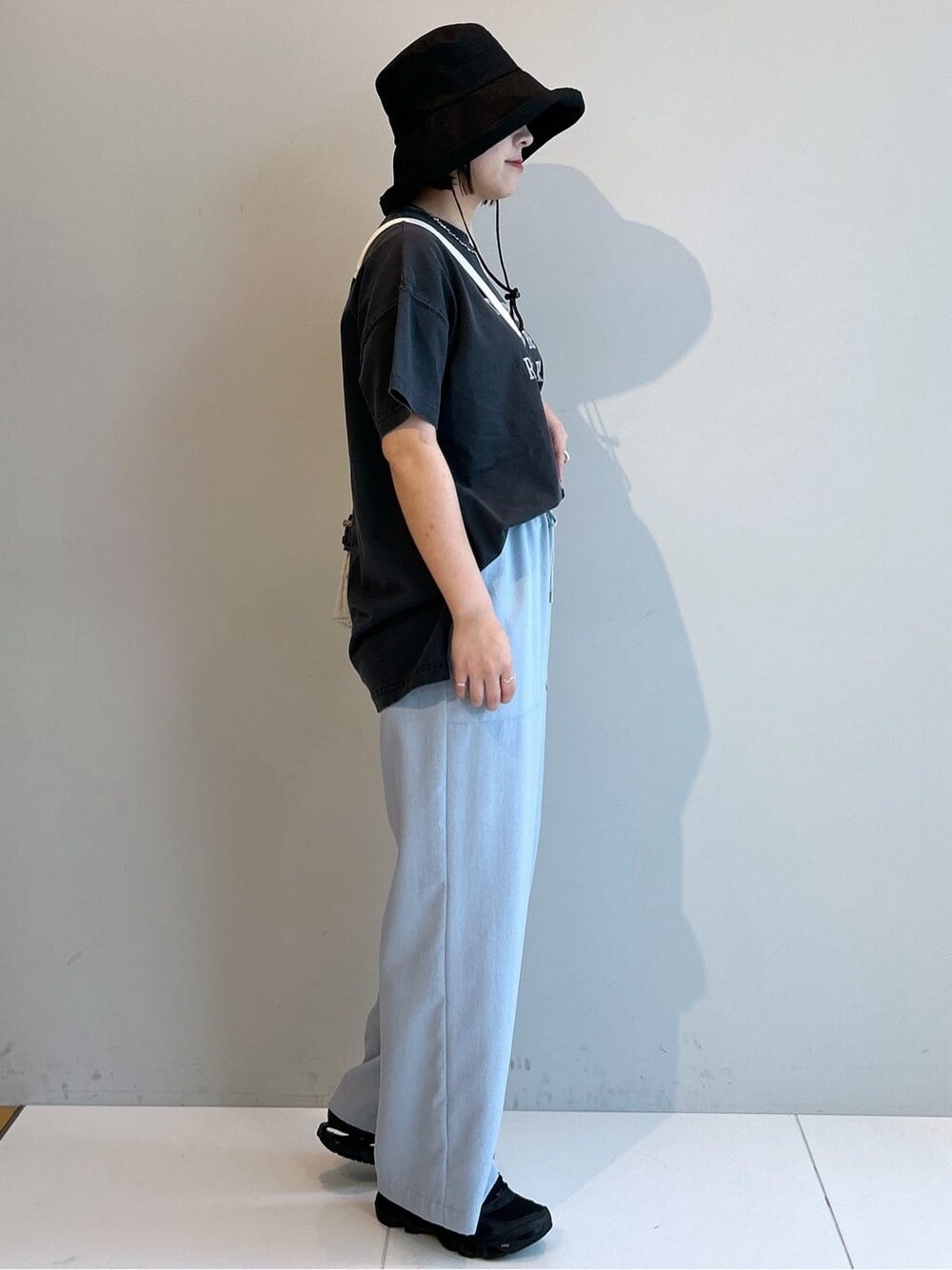 グレー系のTシャツ/カットソー、ブルー系のその他パンツ、ホワイト系のショルダーバッグを着用したレディースの春コーディネートの4枚目の写真