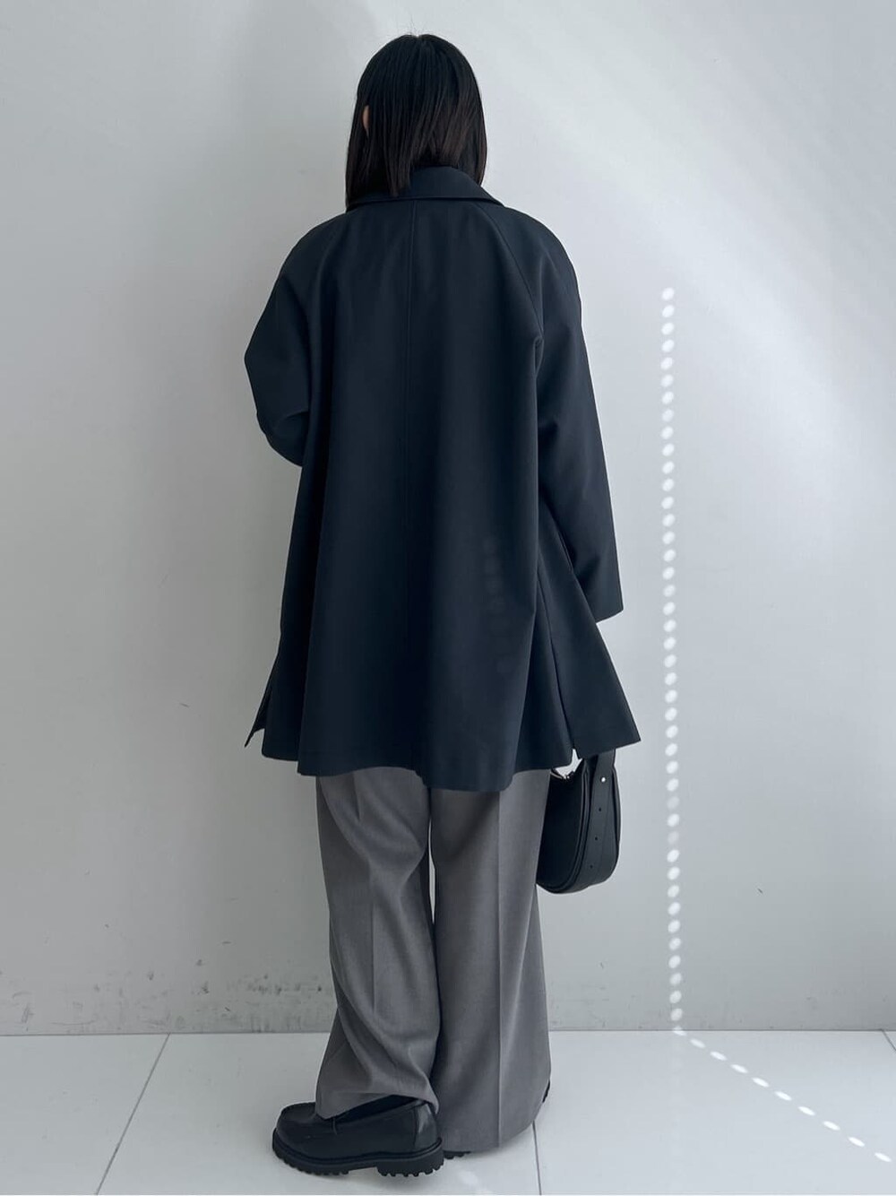 ブルー系のステンカラーコート、ブルー系のニット/セーター、グレー系のその他パンツを着用したレディースの冬コーディネートの3枚目の写真