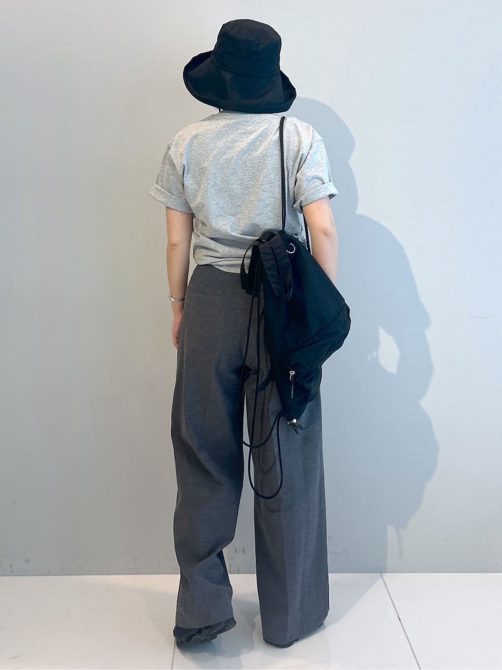 グレー系のTシャツ/カットソー、グレー系のその他パンツ、ブラック系のバックパック/リュックを着用したレディースの春コーディネートの3枚目の写真