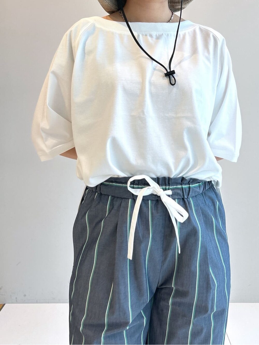 ホワイト系のTシャツ/カットソー、ブルー系のその他パンツ、ベージュ系のハットを着用したレディースの春コーディネートの8枚目の写真