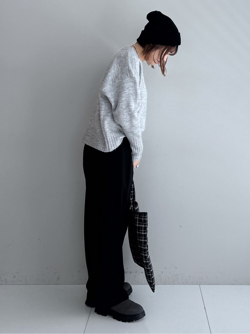 グレー系のニット/セーター、ブラック系のその他パンツ、グレー系のブーツを着用したレディースの秋コーディネートの4枚目の写真