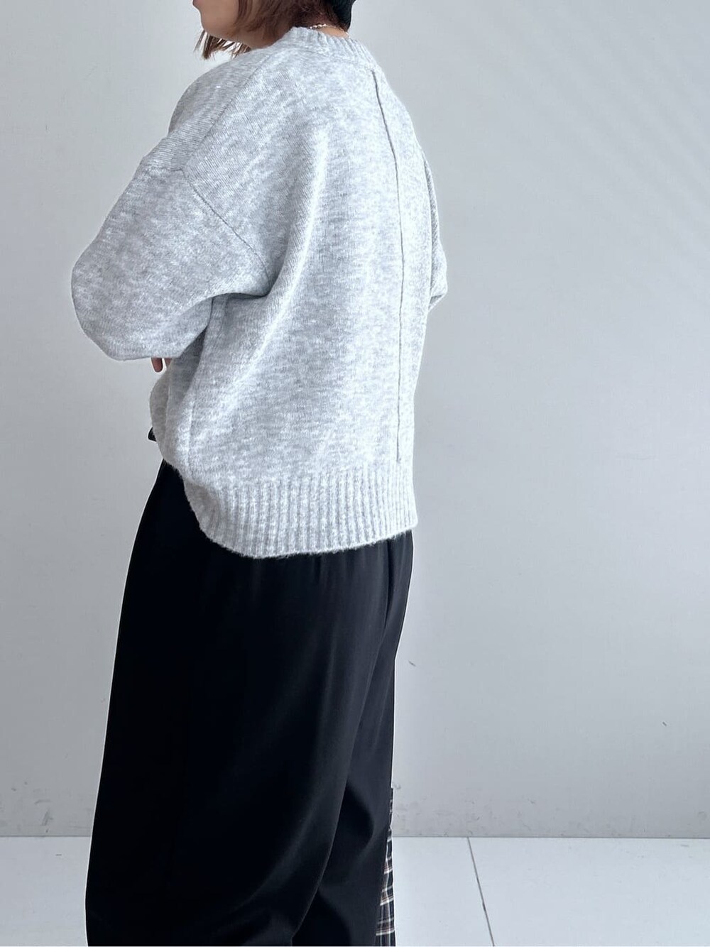 グレー系のニット/セーター、ブラック系のその他パンツ、グレー系のブーツを着用したレディースの秋コーディネートの7枚目の写真