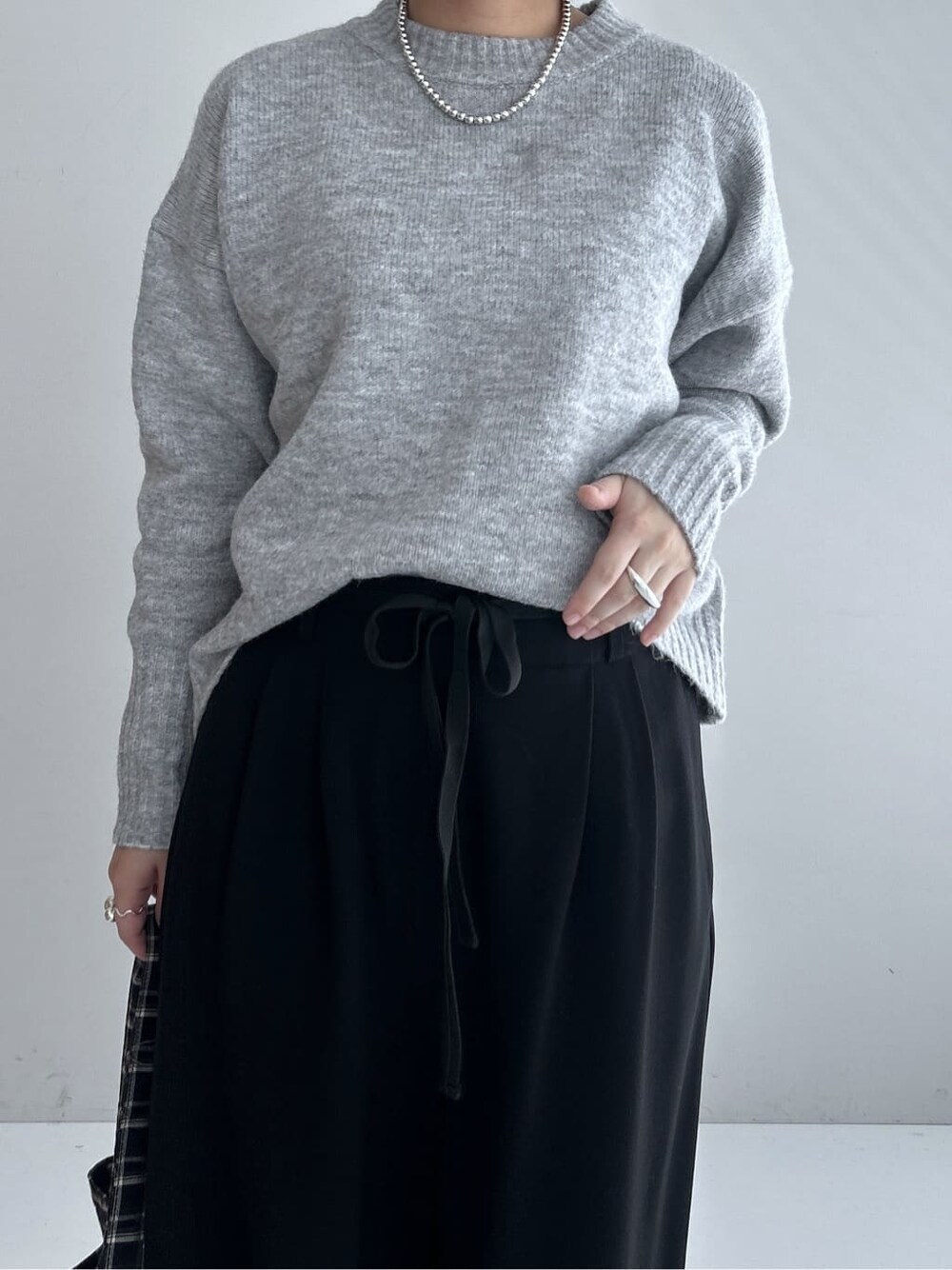 グレー系のニット/セーター、ブラック系のその他パンツ、グレー系のブーツを着用したレディースの秋コーディネートの5枚目の写真