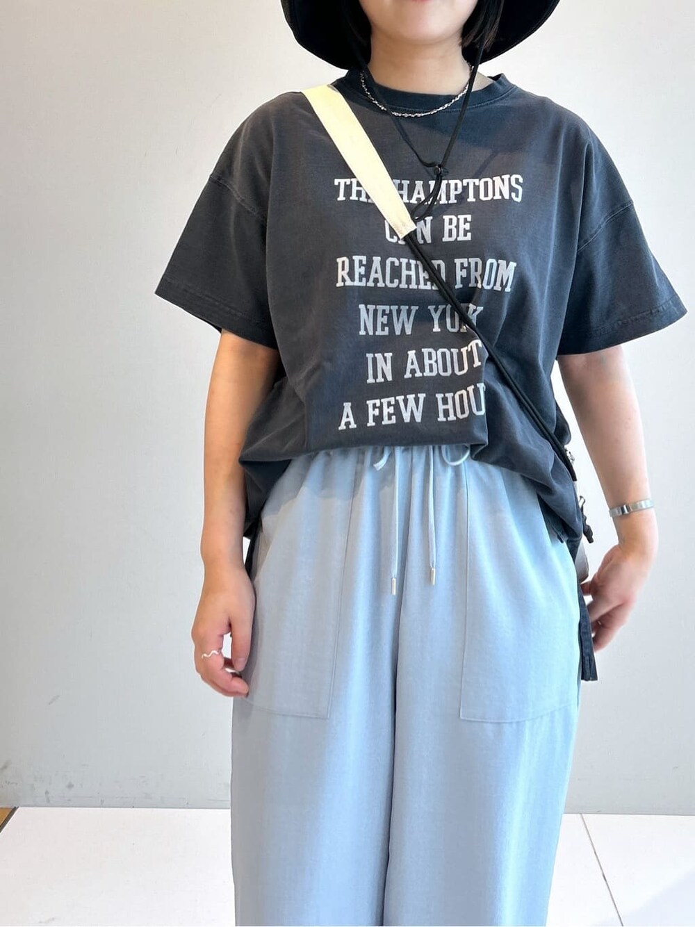グレー系のTシャツ/カットソー、ブルー系のその他パンツ、ホワイト系のショルダーバッグを着用したレディースの春コーディネートの7枚目の写真