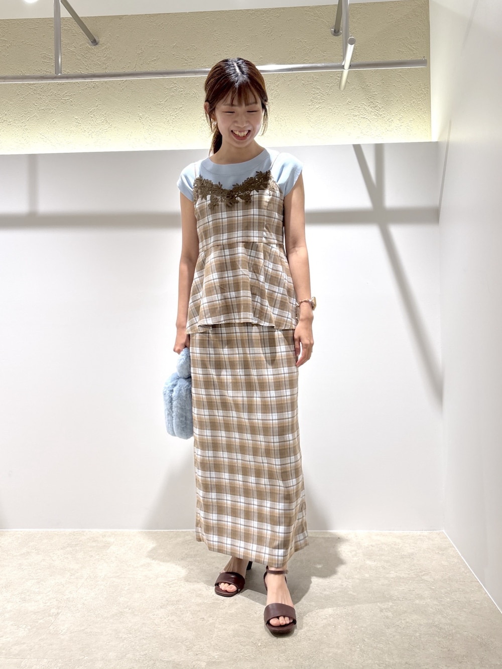 ベージュ系のセットアップ、ブラウン系のサンダル、ブルー系のニット/セーターを着用したレディースの夏コーディネートの3枚目の写真